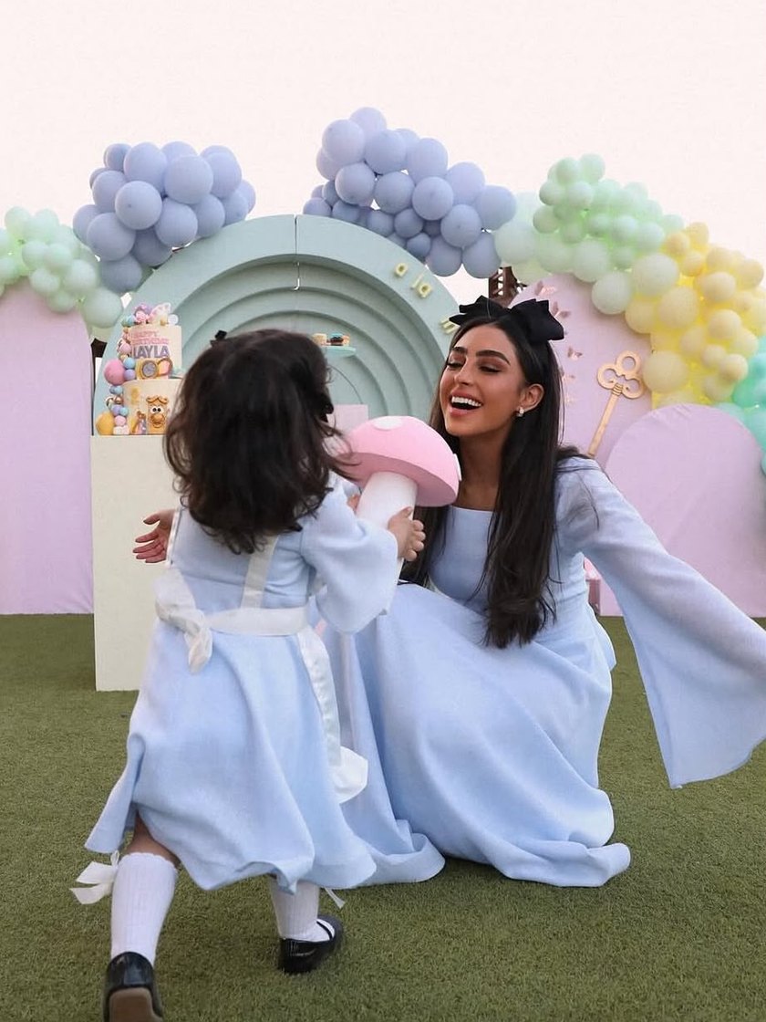 Mother and daughter in matching blue at a pastel balloon birthday set by DT Events