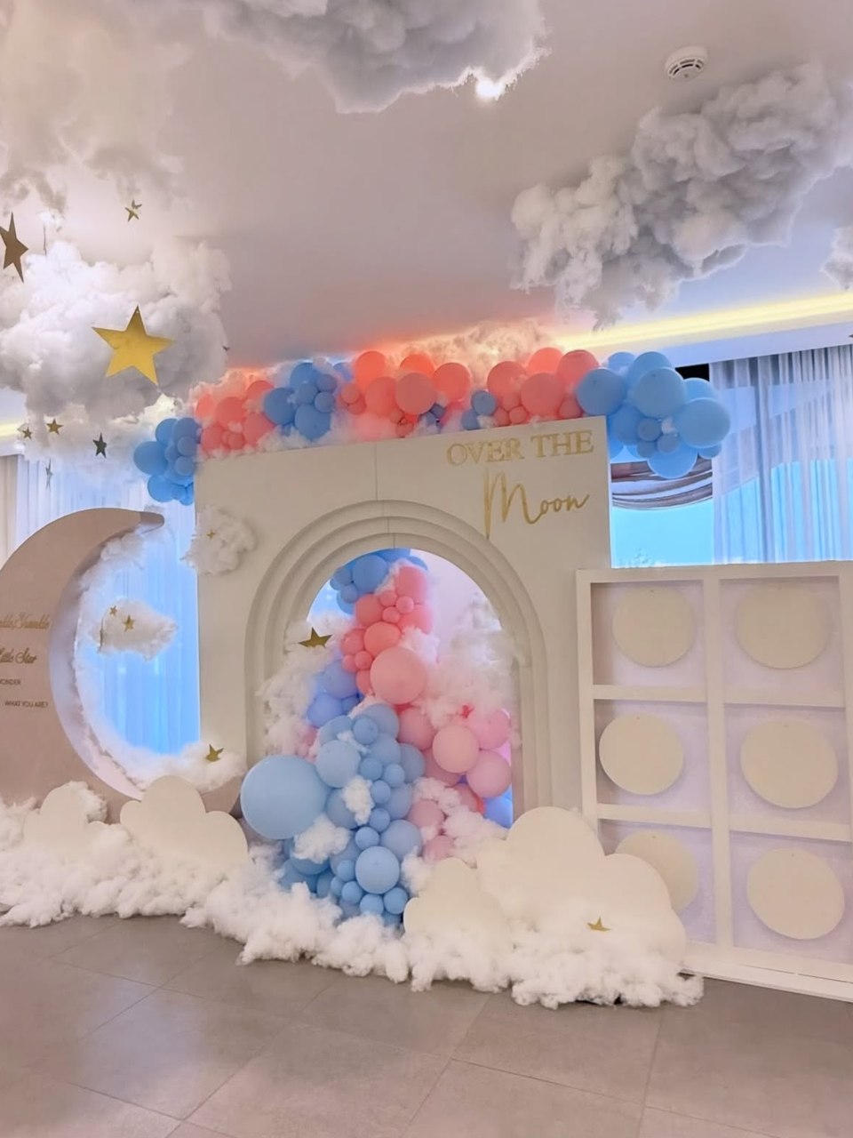 Pastel “Over the Moon” celebration set with cloud installations, balloon garlands and a moon backdrop by DT Events